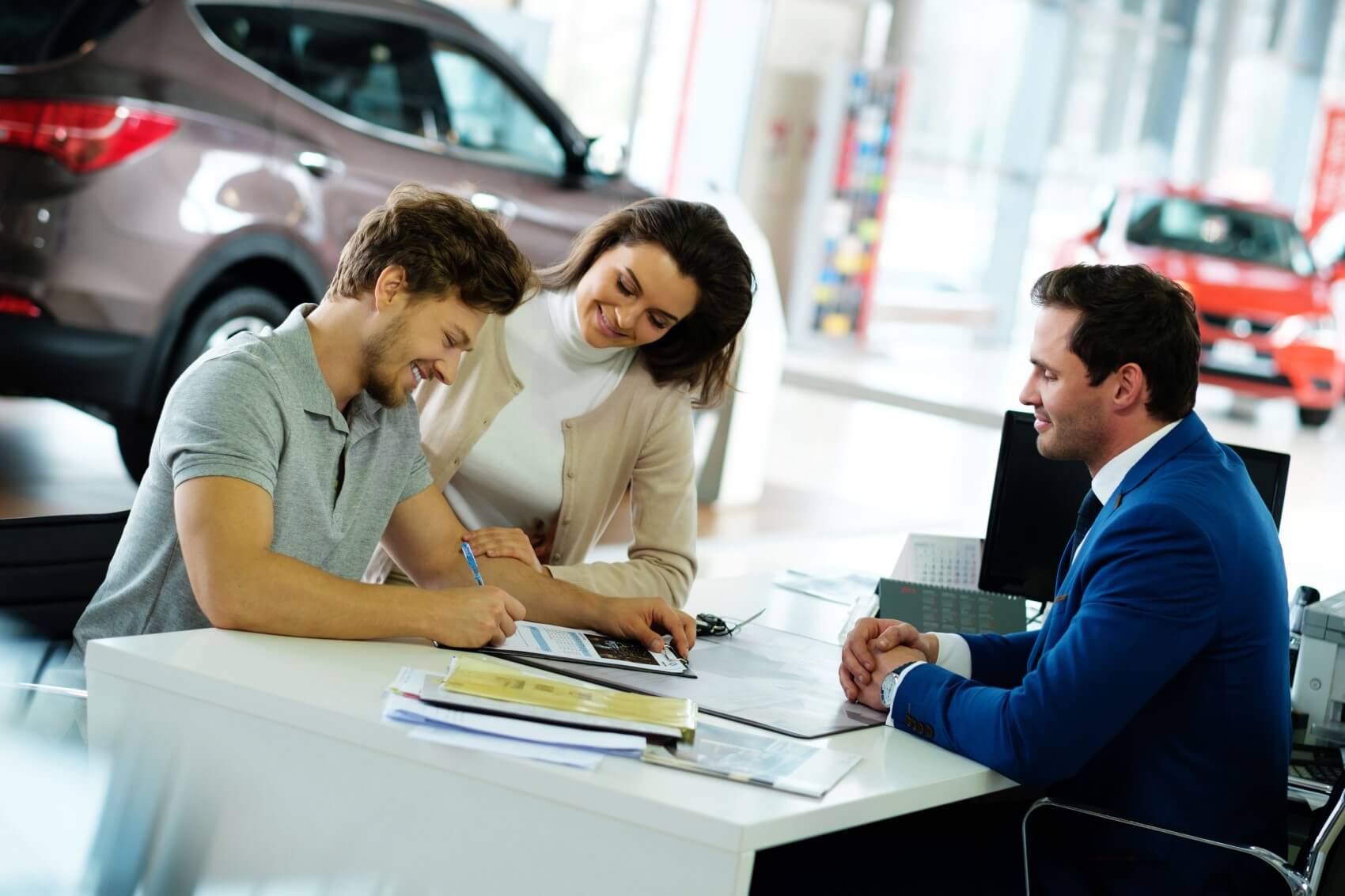 Couple signing lease papers for new Ford vehicle at Ford Finance Center