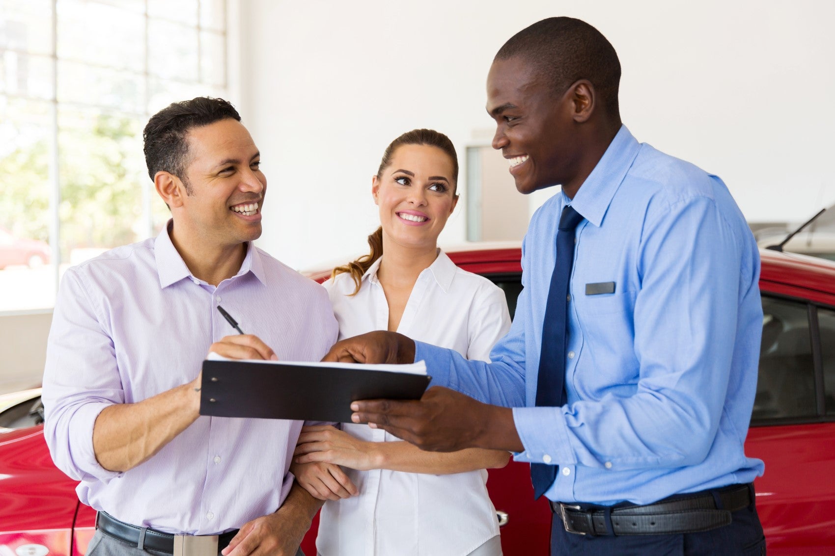 Ford Finance Center member helping couple sign paperwork for a new Ford vehicle